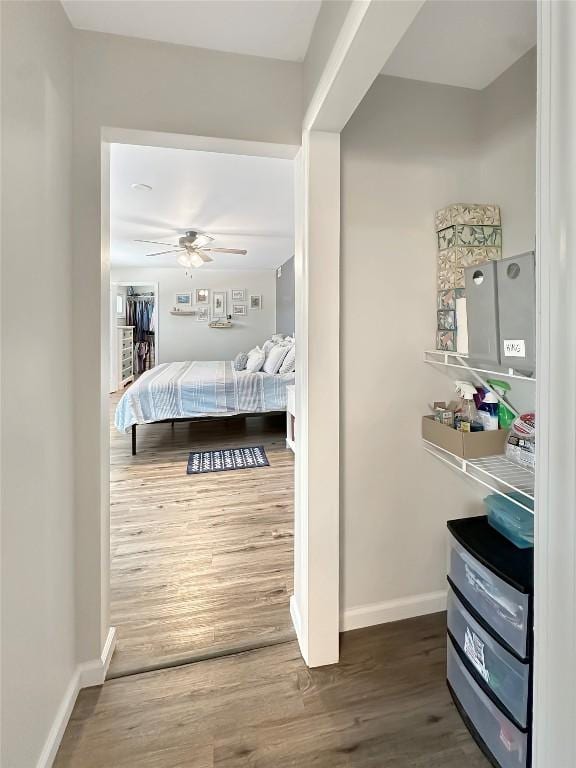 bedroom featuring a ceiling fan, baseboards, and wood finished floors