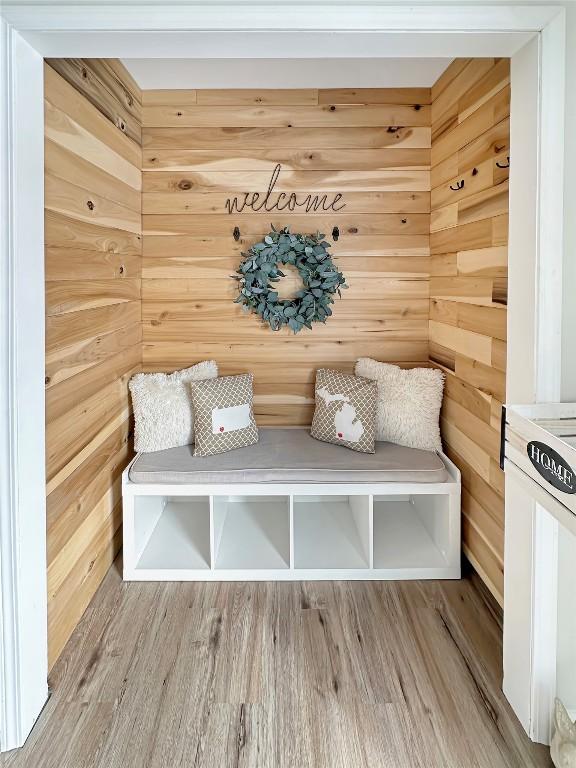 mudroom featuring wooden walls and wood finished floors