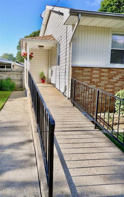 exterior space featuring brick siding and fence