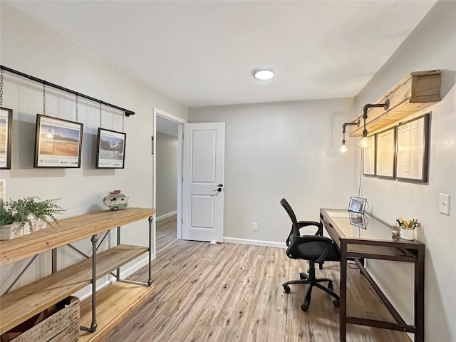 office space with light wood-type flooring and baseboards