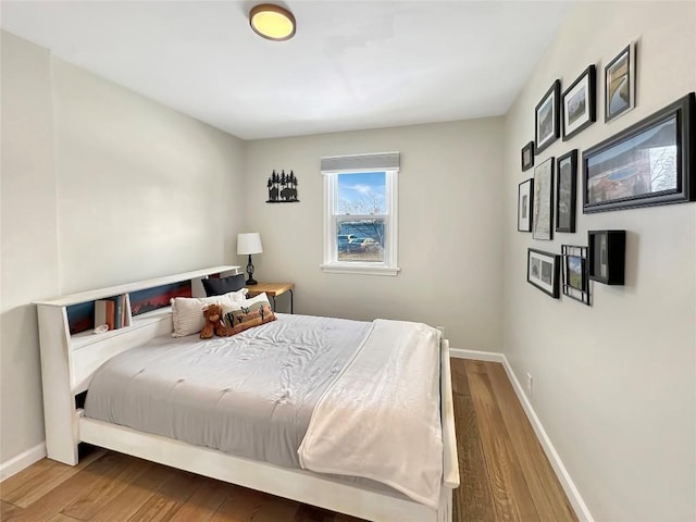 bedroom with baseboards and wood finished floors