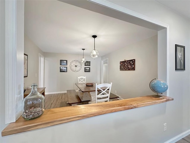 dining area with baseboards and wood finished floors