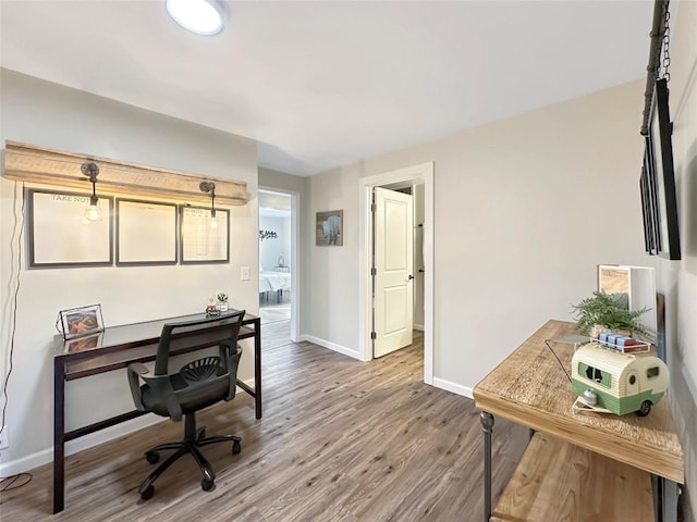 home office with baseboards and wood finished floors