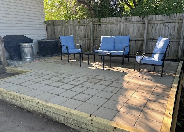 view of patio / terrace with a grill, fence, and cooling unit