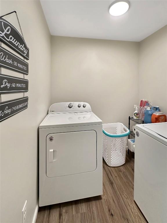 laundry area featuring laundry area, washing machine and dryer, and dark wood-style floors