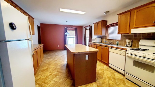 kitchen with white appliances, sink, a kitchen island, hanging light fixtures, and tasteful backsplash