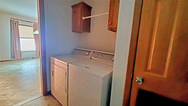 laundry area with washing machine and dryer and cabinets