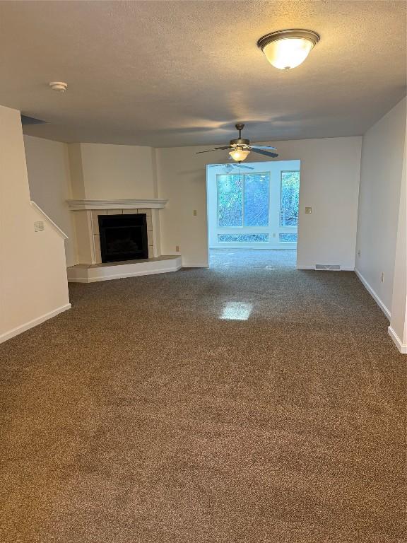 unfurnished living room featuring ceiling fan and a textured ceiling