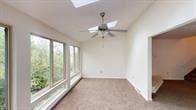 unfurnished sunroom featuring vaulted ceiling with skylight and ceiling fan