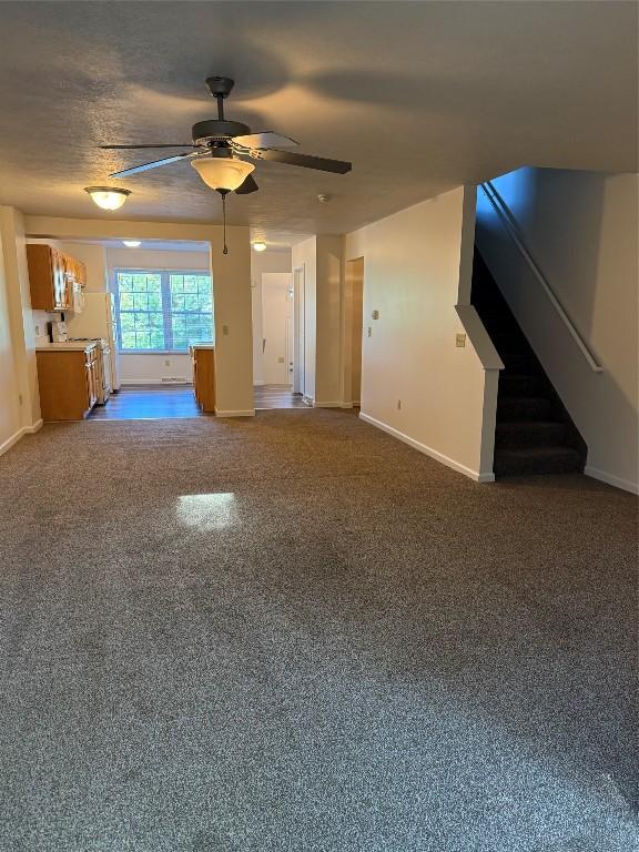 unfurnished living room with ceiling fan