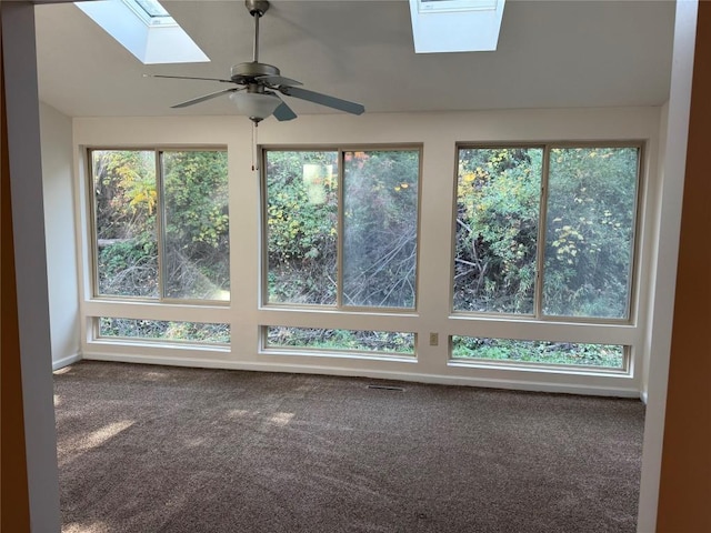 unfurnished sunroom featuring ceiling fan, plenty of natural light, and a skylight