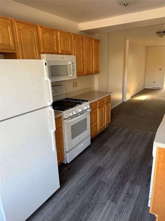 kitchen with dark wood-type flooring and white appliances