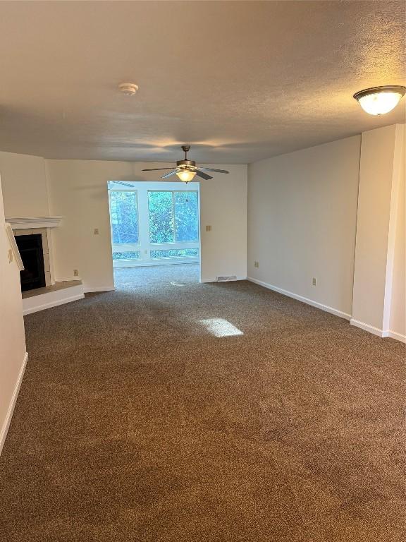 carpeted empty room with a textured ceiling and ceiling fan