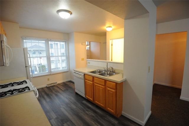 kitchen with white appliances, dark wood-type flooring, and sink