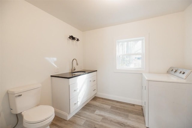 interior space featuring vanity, toilet, wood-type flooring, and washer / clothes dryer