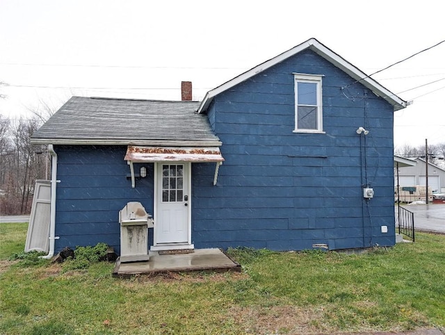 rear view of property featuring a lawn