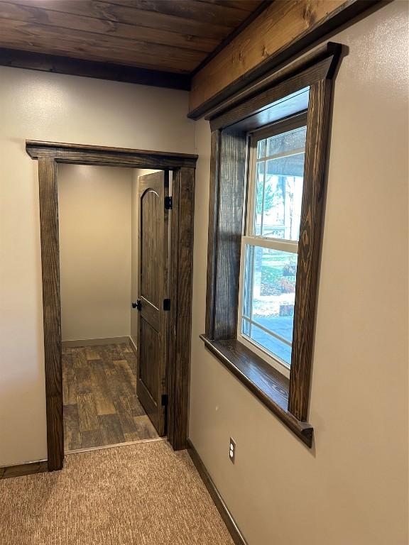 corridor with dark carpet and wooden ceiling