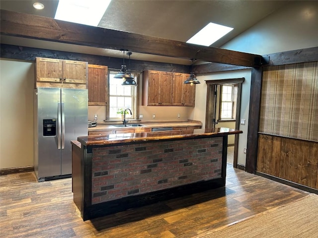 kitchen featuring stainless steel fridge, light hardwood / wood-style flooring, pendant lighting, and sink