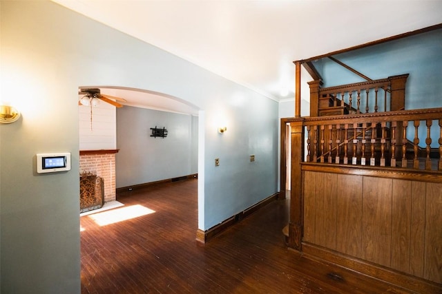 interior space featuring dark wood-type flooring, ornamental molding, and lofted ceiling