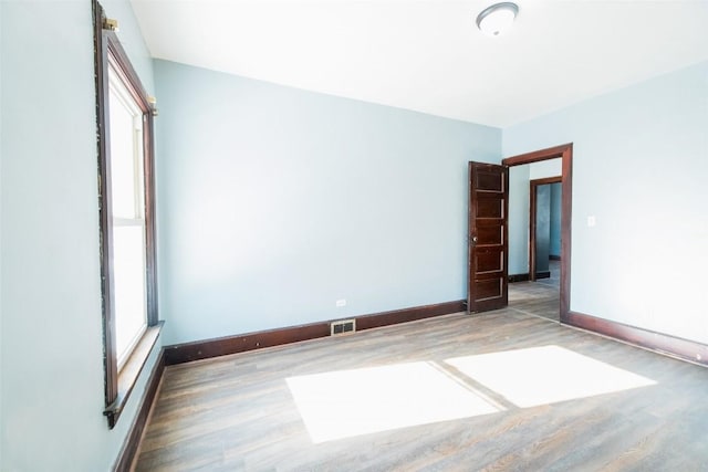 spare room featuring dark wood-type flooring and a wealth of natural light