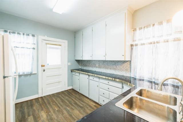 kitchen with dark hardwood / wood-style floors, sink, white fridge, and white cabinets