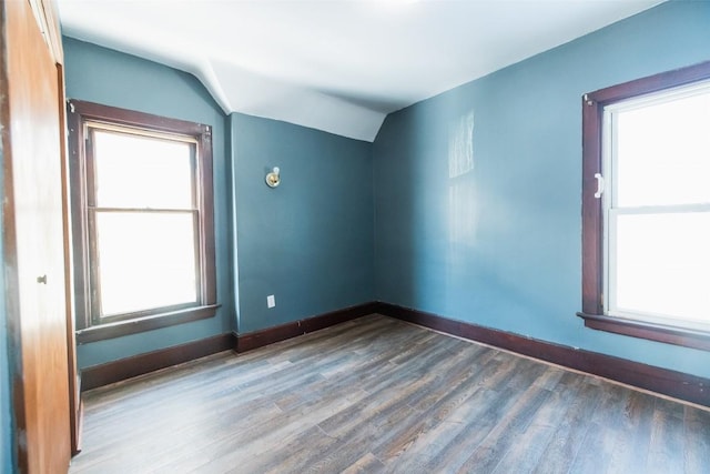 empty room with hardwood / wood-style flooring and lofted ceiling