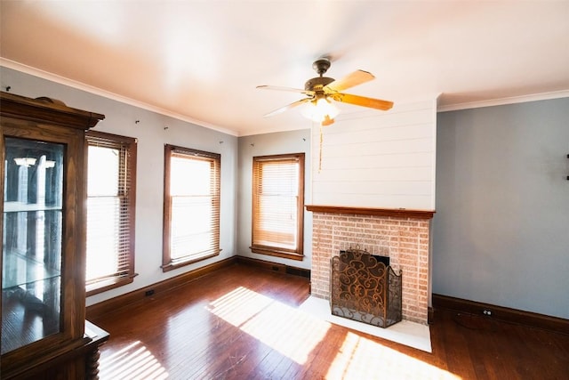 unfurnished living room featuring dark hardwood / wood-style flooring, a fireplace, ornamental molding, and ceiling fan