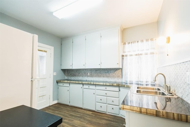 kitchen featuring dark hardwood / wood-style flooring, sink, backsplash, and white fridge