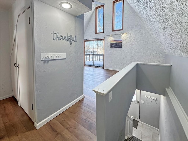 stairs with hardwood / wood-style flooring and lofted ceiling