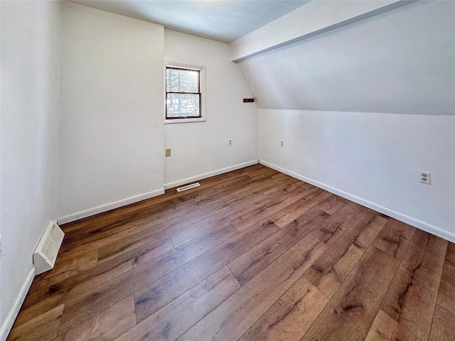 additional living space with dark hardwood / wood-style flooring and vaulted ceiling