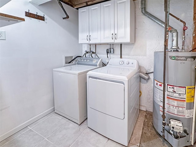 laundry room featuring water heater, washer and dryer, and cabinets