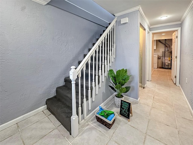 stairway featuring tile patterned flooring, crown molding, gas water heater, and washer and clothes dryer