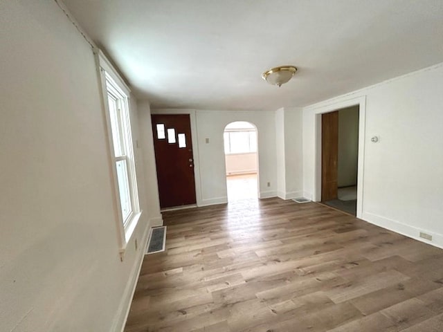 foyer entrance with visible vents, baseboards, and wood finished floors