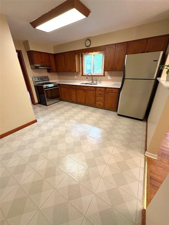 3322 Patio Dr, Millcreek, PA 16506 - kitchen featuring gas stove, freestanding refrigerator, a sink, light countertops, and light floors