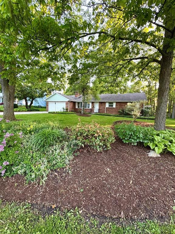 3322 Patio Dr, Millcreek, PA 16506 - view of front facade featuring an attached garage, brick siding, and a front lawn
