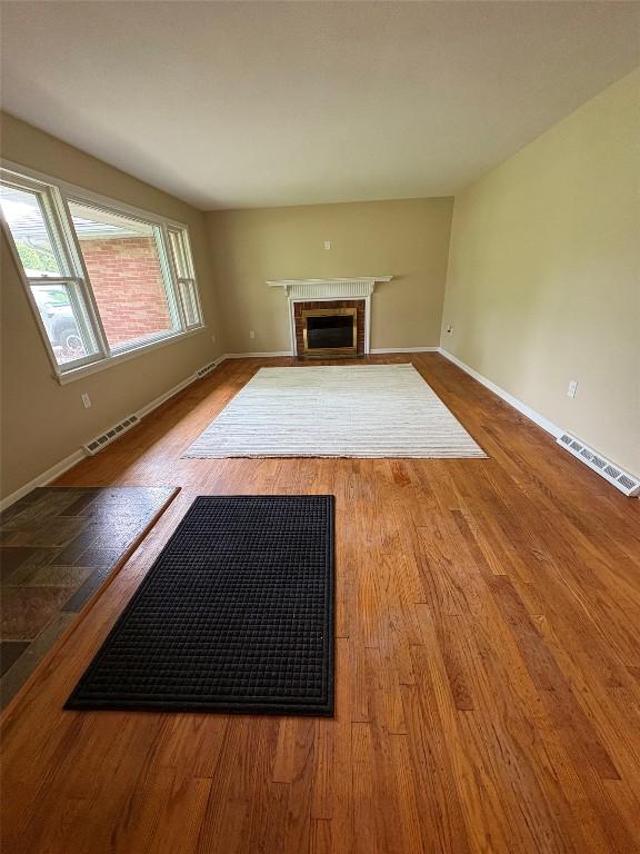 3322 Patio Dr, Millcreek, PA 16506 - unfurnished living room with wood finished floors, baseboards, and a glass covered fireplace
