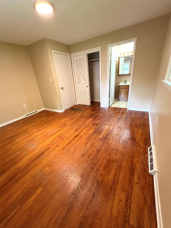 3322 Patio Dr, Millcreek, PA 16506 - unfurnished bedroom with wood finished floors, a closet, baseboards, and ensuite bathroom