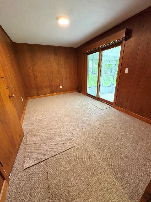 3322 Patio Dr, Millcreek, PA 16506 - empty room with wooden walls, light colored carpet, and baseboards