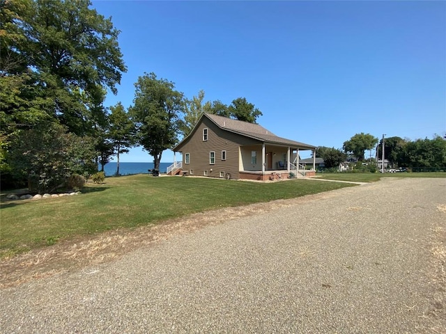 view of side of home with a yard and covered porch