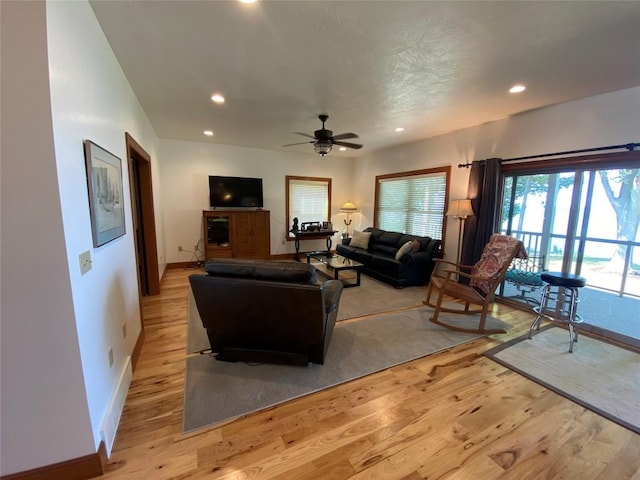 living room featuring ceiling fan and light hardwood / wood-style flooring