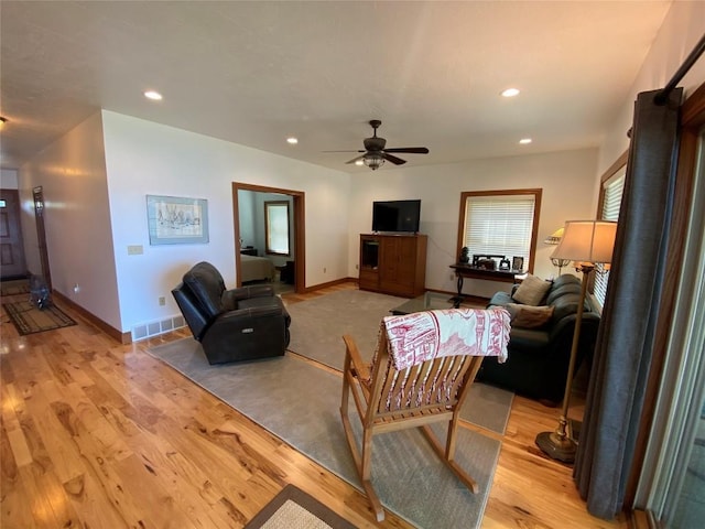 living room featuring ceiling fan and light hardwood / wood-style floors