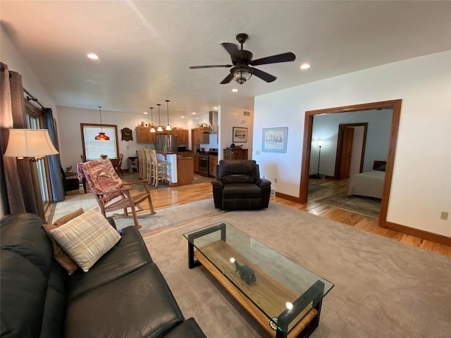 living room featuring light hardwood / wood-style floors and ceiling fan