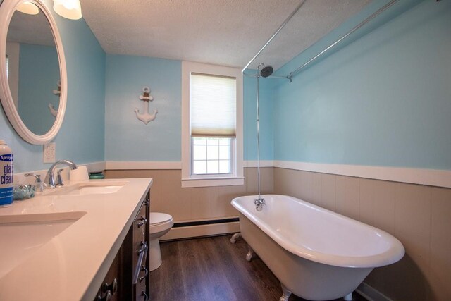 5499 Pinetree Rd, Mckean, PA 16426 - full bath with a baseboard radiator, a wainscoted wall, a soaking tub, wood finished floors, and a textured ceiling