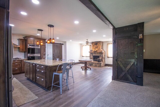 5499 Pinetree Rd, Mckean, PA 16426 - kitchen with stainless steel double oven, open floor plan, recessed lighting, ceiling fan, and a fireplace