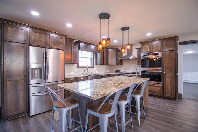 5499 Pinetree Rd, Mckean, PA 16426 - kitchen with appliances with stainless steel finishes, wall chimney exhaust hood, dark wood finished floors, dark brown cabinets, and recessed lighting