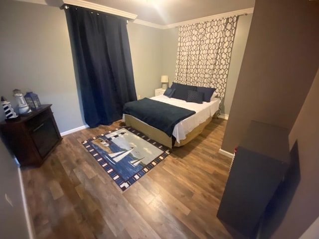 bedroom with crown molding and dark hardwood / wood-style flooring