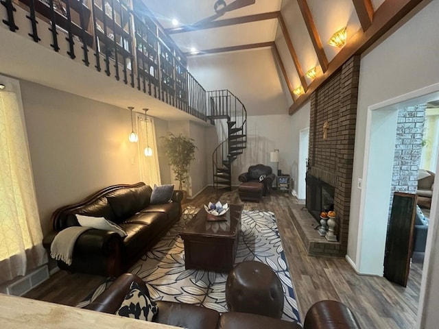 living room featuring hardwood / wood-style floors, high vaulted ceiling, a brick fireplace, and beam ceiling