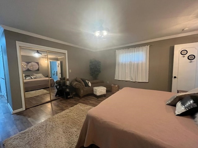 bedroom with dark hardwood / wood-style flooring, ornamental molding, and a closet