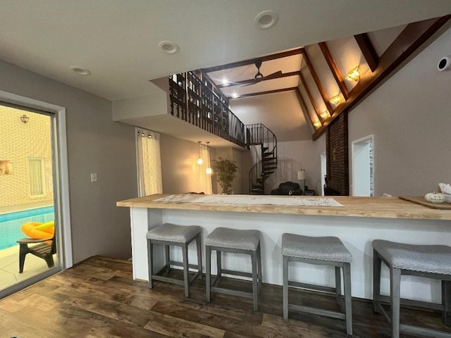 kitchen featuring dark hardwood / wood-style flooring, ceiling fan, and a breakfast bar area