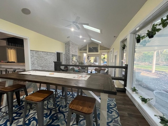 interior space featuring lofted ceiling with skylight, ceiling fan, and dark wood-type flooring